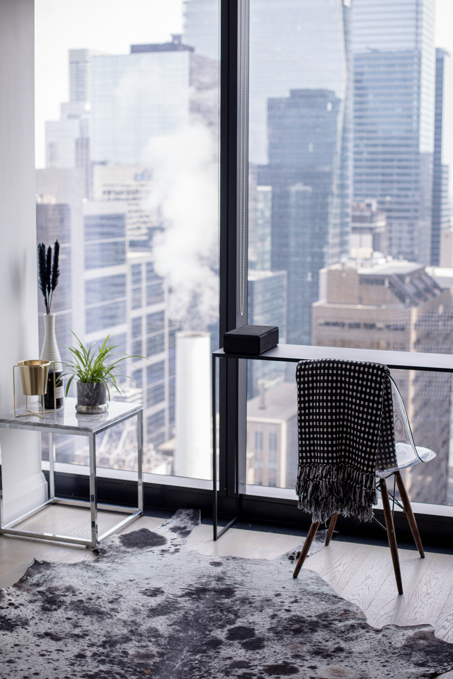 Office desk and chair beside a window overlooking the city